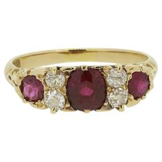 Here we have a classically styled three-stone ruby and diamond ring. This antique piece has been crafted from 18ct yellow gold and showcases a trio of rich red rubies; the largest of which sits at the centre. These focal stones are separated and accentuated by a duo of round faceted old mine cut diamonds atop of one another on either side. An ornate under-gallery design continues onto either shoulder before the piece is made complete by an otherwise plain shank. Condition: Used (Very Good) Weight: 3.8 grams Ring Size: N 1/2 (55) Band Width: 2mm Face Dimensions: 18mm x 6mm Ruby Weights: Approx. 1 (0.80ct), 2 (0.15ct) Total Diamond Weight: Approx. 0.28ct Marked: '18CT' Box: The Vintage Jeweller Ring Box Face Dimensions, Ruby And Diamond Ring, Ruby Diamond Rings, Gallery Design, Ruby Diamond, Three Stone Rings, Ruby Ring, Ring Box, Three Stone