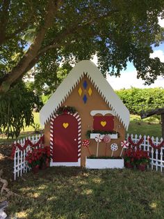 a gingerbread house is decorated with flowers and candy canes for the holiday season