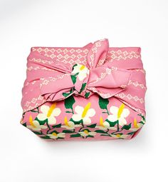 a pink flowered box with a bow on it