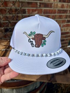 Stay stylish and protected from the sun with our Cattle Drive Couture White SnapBack Trucker Hat. Featuring a unique Dice Hat Chain, this hat adds a touch of western flair to any outfit. Made with high-quality materials for ultimate comfort and durability. Western Trucker Hat, Dice Hat, Hat Chain, Curvy Girl Dress, Cattle Drive, Macbook Air Cover, Rancher Hat, Concho Belt, Casual Bottoms