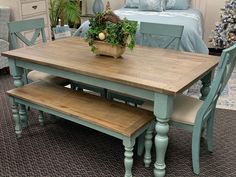 a kitchen table with two benches in front of it and a christmas tree behind it