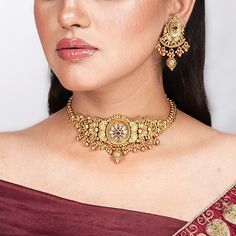 India Necklace Antique Gold Choker with Ruby Kundan embodies the essence of South Indian jewelry, reminiscent of Amrapali's iconic designs. This temple-inspired statement piece, perfect as a Bollywood wedding gift, radiates traditional elegance and cultural heritage. Ideal for her special occasions, it celebrates craftsmanship and timeless allure. *𝐏𝐑𝐎𝐃𝐔𝐂𝐓 𝐃𝐄𝐓𝐀𝐈𝐋* * Material: Brass * Plating: Gold Plated * Stone: Semi Precious Stones.  *𝐃𝐈𝐌𝐄𝐍𝐒𝐈𝐎𝐍𝐒* * Necklace:- Weight: 56 Traditional Gold Wear For Eid, Gold Traditional Wear For Eid, Festive Gold Cutdana Tikka, Gold Temple Jewelry Tikka As Gift, Yellow Gold Kundan Necklace With Meenakari For Puja, 22k Gold Temple Necklace With Tilla For Puja, Gold Temple Jewelry Tikka For Eid, Temple Jewelry Tikka With Intricate Design As Gift, Gold Bollywood Tikka With Meenakari Detailing