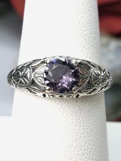 Simulated or Natural Amethyst Ring Etched Wedding Design#160 Made To Order Here we have a Victorian/Edwardian reproduction ring in sterling silver with a stunning Simulated(Natural option available) amethyst gemstone. This full cut round purple amethyst gem is 6mm in diameter. The inside of the band is marked 925 for sterling. Notice the beautiful floral design of the silver and gold filigree setting and band. This is a lovely rendition of an Antique filigree ring; and it is ready to wear. A gif Antique Filigree, Amethyst Gem, Pearl Design, Gold Filigree, Filigree Ring, Engraved Items, Favorite Rings, Make Design, Topaz Ring