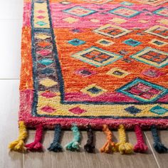 a colorful rug with tassels on the floor