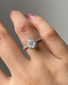 a woman's hand with a diamond ring on top of her finger and an engagement band