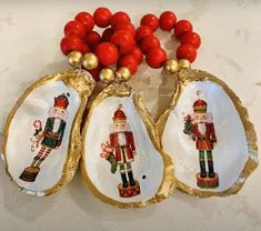 three christmas ornaments with red beads and gold trimmings on white marble counter top