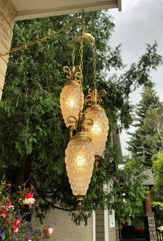 two chandeliers hanging from the side of a house