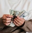 an older man holding money in his hands