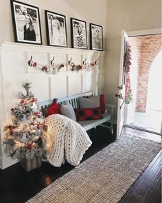 a living room with a christmas tree and pictures on the wall