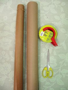 two rolls of brown paper next to scissors and tape