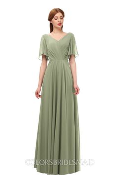 a woman in a long green dress with sleeves on the shoulders and shoulder, standing against a