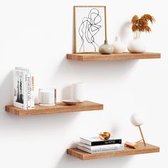 two wooden shelves with books and vases on them