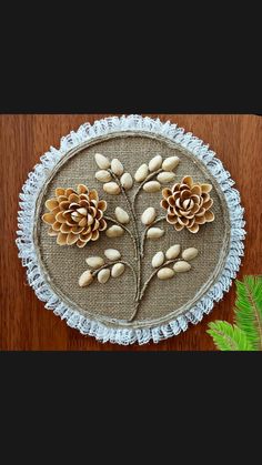 an embroidered piece with pine cones and leaves on it