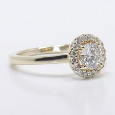 a yellow gold ring with a diamond center