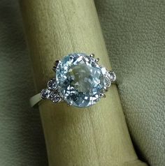 "The center stone is a natural oval 10 x 8 mm light blue aquamarine The band is accented with 6 diamond total weight aprox .21 cts . Diamond clarity VS2-SI and H color range. The setting can be made in 14k rose, yellow or white gold. We can make it any size from 5-7 and you still be able to return it within the listed time frame. Sizing outside of that range requires a resize fee if for any reason the ring is retuned. Ring sizing may add additional handling time. We love this ring because it rep Rose Yellow, Aquamarine Blue, Diamond Clarity, Oval Cut, Diamond Rings, Aquamarine, Heart Ring, Diamond Earrings, Light Blue