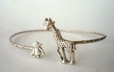 I handcrafted this bracelet using a vintage metal delicate bracelet base, a silver plated giraffe and a silver plated penguin. The parts are soldered and not glued.The bracelet is adjustable.It comes in a gift box. Extra little GIFT included separately with the packaging!More Rings selection: www.etsy.com/shop/stavri?section_id=7346628More Bracelets selection: www.etsy.com/shop/stavri?section_id=7133840More Necklaces selection: www.etsy.com/shop/stavri?section_id=6926501For more jewelry designs, Cute Silver Charm Bracelet Bangle, Cute Silver Bangle Charm Bracelet, Whimsical Adjustable Metal Bracelets, Unique Metal Charm Bracelet As Gift, Unique Nickel-free Charm Bracelet As Gift, Unique Adjustable Metal Charm Bracelet, Adjustable Unique Metal Charm Bracelet, Unique Sterling Silver Charm Bracelet Gift, Cute Handmade Silver Charm Bracelet