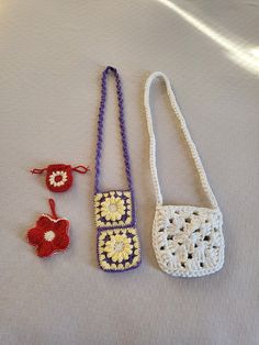 three crocheted purses are laying next to each other on a white surface