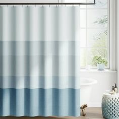 a blue and white shower curtain in a bathroom with a bathtub next to it