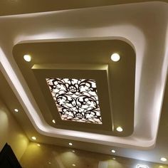 the ceiling in this room is decorated with white and black designs, including a decorative glass window