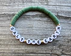 a green and white beaded bracelet with words on it