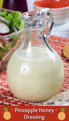 a glass pitcher filled with dressing sitting on top of a table