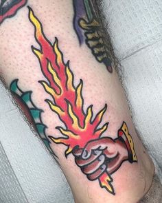 a person with a tattoo on their leg that has flames coming out of the legs