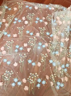 the sheer fabric has blue and white flowers on it