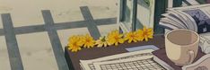 a table topped with yellow flowers next to an open book and cup filled with coffee