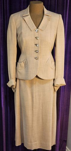 This beautiful 1940s suit is in excellent vintage condition.  There is a soft shoulder pad on each side.  The side zipper has been replaced with a nylon one that matches the pink blush color of the suit exactly.  Closure is via the 5  3/4" exquisite frosted white and bronze buttons - each with a rhinestone in its center.   Please be sure to note the fold in the center of each of the 6" curved pouch pockets at each hip; this same fold is featured on the 2" wide collar.  There is a 6" kick pleat in the back of the skirt.  The jacket is lined in a clay color satin.  Each sleeve features a 2" open cuff. Approximate measurements:      jacket shoulder to shoulder:  15" arm pit to arm pit:  18" waist:  28" hips:  33" back length:  24" sleeve length:  22"     skirt waist:  24" hips:  34" skirt len 1940s Suits Women, Vintage Fitted Skirt Suit With Notch Lapel, Classic Fitted Skirt Suit With Button Closure, Classic Notch Lapel Skirt Suit With Buttons, Classic Skirt Suit With Notch Lapel, Tailored Classic Skirt Suit, Retro Formal Skirt Suit With Buttons, Vintage Formal Skirt Suit With Button Closure, Vintage Skirt Suit With Button Closure For Formal Occasions