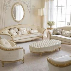 a living room filled with white furniture and lots of pillows on top of it's couches