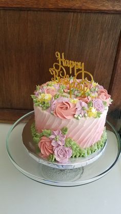 a pink and green cake with flowers on it