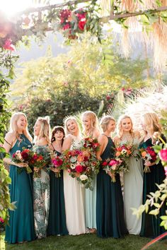 a group of women standing next to each other holding bouquets