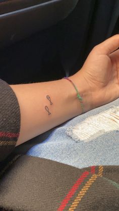 a woman's arm with a small anchor tattoo on her left wrist and the word love written in cursive writing