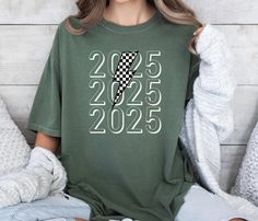 Introducing our 2025 Shirt - a sleek and stylish way to celebrate the upcoming year! Perfect for graduates, event planners, or anyone excited about what 2025 has in store, this shirt features a bold design that marks the milestone of a new chapter DETAILS: ✨ Material: Made from plush 100% ring-spun cotton for ultimate comfort. ✨ Fit: Relaxed charm that effortlessly blends style and ease. ✨ Softness: Enchantingly soft-washed fabric for daily bliss. 📍SIZING📍 ✨ Unisex Universe: The sizing isn't j Senior Shirts, Graduation Shirts, Comfort Colors Shirt, Event Planners, Bold Design, Lightning Bolt, New Chapter, Festival Season, Comfort Colors