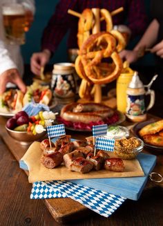 a table topped with lots of food and pretzels