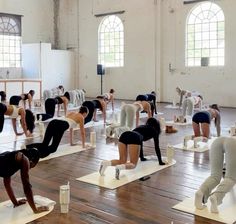 a group of people doing yoga in a large room