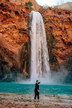 a person standing in front of a waterfall