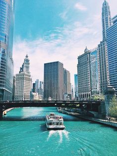 a boat traveling down the river in front of tall buildings