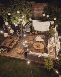 an overhead view of a backyard with lights and furniture on the deck, surrounded by greenery