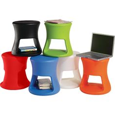 four different colored stools sitting next to each other in front of a white background