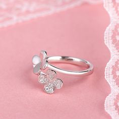 If your are looking for a little lovely ring, then this ring is a nice choice. Two clover shapes are sculptured on the sterling silver bypassing shank.One clover is set with small round-cut stones to add sparkle to the ring. With the high polished shank,the ring will show a very elegant look on your finger.Treat yourself or surprise her with this dainty lovely ring!Carat Weight: 0.12 ctStone Size: 1.1 mmStone Type: Jeulia® StoneNumber of Stones: 12 Stone Color: Diamond WhiteStone Shape: RoundWei Silver Flower Ring With Diamond Accents, Silver Sterling Butterfly Ring With Diamond Accents, Sterling Silver Flower Ring In Diamond White, Sterling Silver Flower Ring With Diamond Accents, Elegant Round Butterfly Ring Stamped 925, Diamond White Sterling Silver Flower Ring, Silver Butterfly Ring With Prong Setting, Sterling Silver Diamond Flower Ring In Fine Jewelry Style, Silver Diamond Flower Shaped Ring