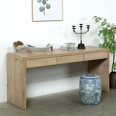 a wooden table with two vases and a painting on the wall in the background