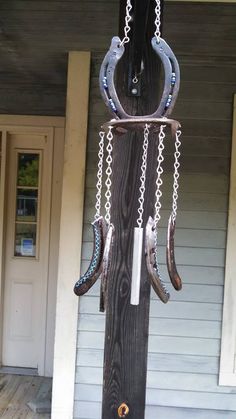 a wooden pole with some metal chains hanging from it's sides and two horseshoes attached to it