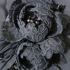 an image of a brooch that is on the table in black and silver colors