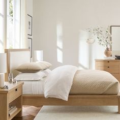 a bedroom with white walls and wooden furniture