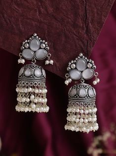 Introducing our exquisite white Statement Jhumkas with Stone Work - a dazzling fusion of tradition and contemporary elegance. These high-quality earrings are meticulously crafted to add a touch of glamour to any outfit, making them the perfect accessory for special occasions or everyday wear. Crafted with precision and attention to detail, these jhumkas are not just stunning but also exceptionally lightweight. You can enjoy the glamour of statement earrings without compromising on comfort. The lightweight design makes them perfect for extended wear, allowing you to dance the night away or confidently carry them throughout your daily activities. Whether you're attending a wedding, a festive celebration, or simply looking to elevate your style, these White Statement Jhumkas with Stone Work a White Cutdana Jhumkas For Wedding, Wedding White Cutdana Jhumkas, White Bridal Earrings With Tilla For Eid, White Tilla Bridal Earrings For Eid, White Jhumkas With Intricate Design For Celebration, White Intricate Design Jhumkas For Celebration, White Chandbalis For Wedding And Diwali, White Jewelry With Latkans For Celebration, White Jhumkas For Wedding And Eid