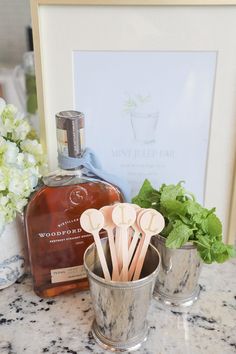 there are toothbrushes in the cup on the counter next to some bottles and flowers