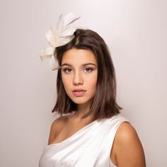 The Bridal Bow Fascinator adorned with long feathers is an elegant wedding hairpiece that adds a touch of elegance to any bride's ensemble. Crafted from millinery sinamay and feathers, this headpiece boasts a unique design. Wear on the side and it will effectively add height. Pictured in light ivory The fascinator is thoughtfully secured with an alligator clip for easy and secure attachment. While lightweight, sinamay is surprisingly durable, ensuring that the fascinator maintains its shape and Elegant Party Fascinator With Feather Trim, Elegant Feathered Fascinator For Party, Elegant Feather Fascinator For Party, Wedding Feather Trim Headband For Royal Ascot, Wedding Headband With Feather Trim For Royal Ascot, Elegant Fitted Feather Trim Headband, Feathered Mini Hats For Wedding And Kentucky Derby, Fitted Feather Hair Accessories For Wedding, Wedding Fascinator With Feather Trim For Royal Ascot