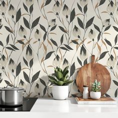 a kitchen counter with potted plants on it and a cutting board in front of the wall