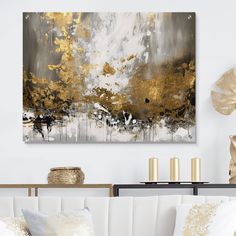 a living room with white couches and gold accents on the wall above it is an abstract painting